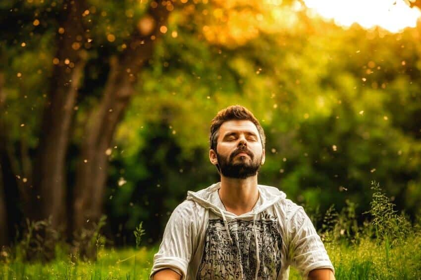 man meditating in forest