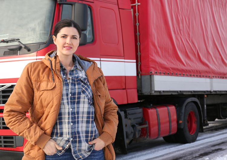 female trucker standing in front of red truck
