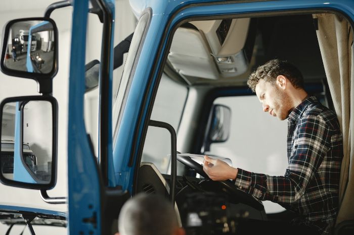 truck driver reading document in his truck